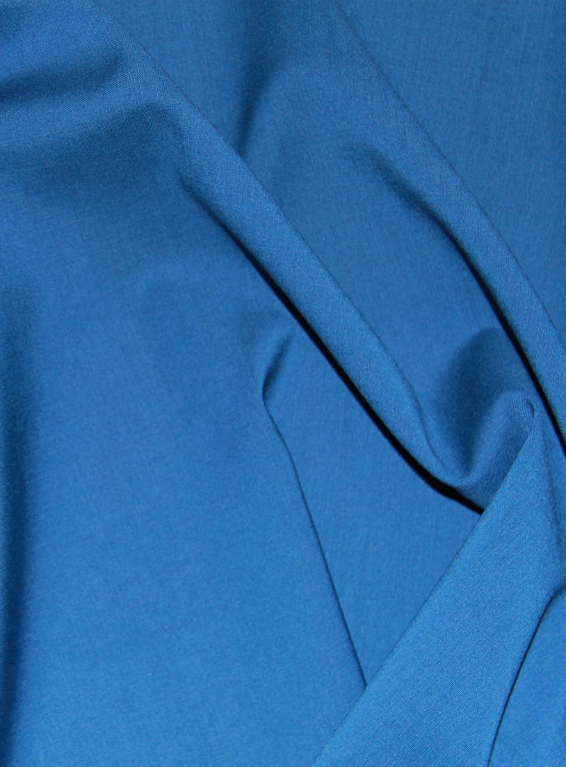 Close-up of blue wool fabric with soft folds and draped creases