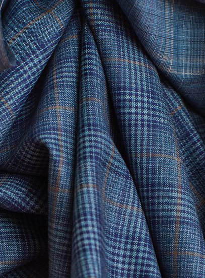 Draped blue wool fabric with a fine check pattern and thin tan overcheck lines