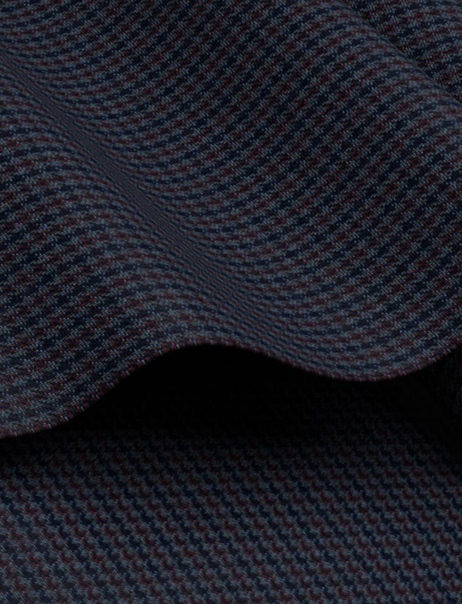 Close-up of draped navy wool fabric with a fine houndstooth weave in blue and burgundy tones