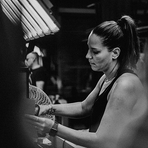 Woman with a ponytail works at a machine in a textile workshop, in black and white