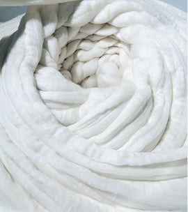 Soft white wool fibre rolled in thick, spiralling coils, shown in close-up