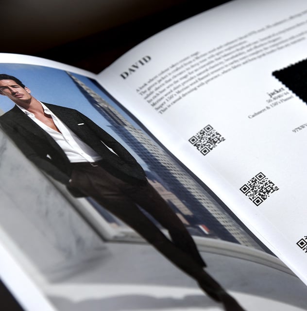 Open catalog page titled "DAVID" with a fabric swatch and QR codes, beside a man in a dark jacket and white shirt