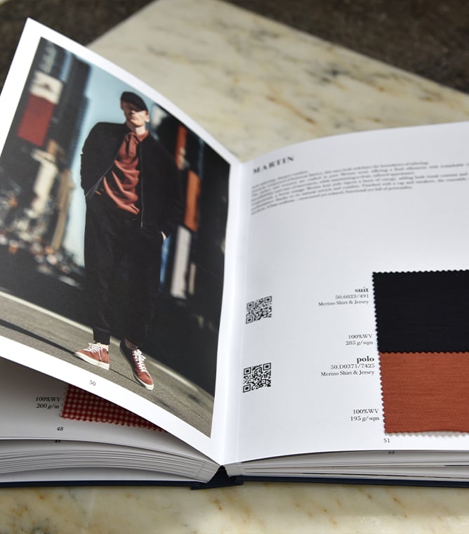 Open swatch book showing a man in a dark jacket and cap, with black and rust fabric samples labeled Martin