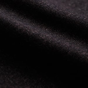 Close-up of dark charcoal wool flannel fabric with soft folds and a fine, slightly speckled texture