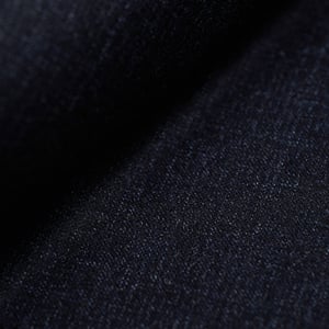 Close-up of dark navy flannel wool fabric with a fine, soft texture and diagonal folds
