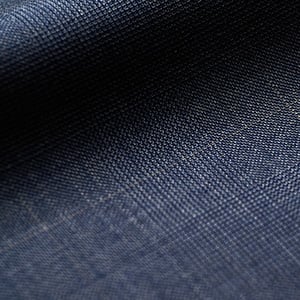 Close-up of navy blue woolen fabric with a fine woven texture and faint light check lines