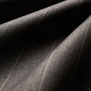 Close-up of dark grey wool fabric with subtle pinstripes, draped in soft folds