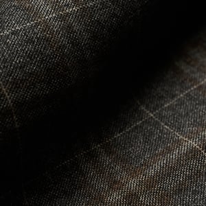 Close-up of dark grey wool fabric with a subtle windowpane check in beige and brown