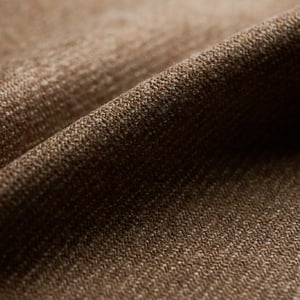 Close-up of brown woolen twill fabric with soft folds and a fine diagonal weave