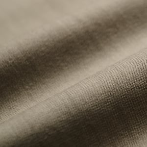 Close-up of taupe-gray fabric with soft folds and a fine woven texture