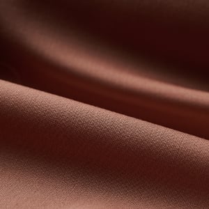 Close-up of soft brown fabric with gentle folds and a fine woven texture