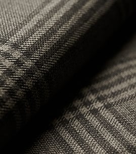 Close-up of folded gray wool fabric with a dark glen check pattern and visible woven texture