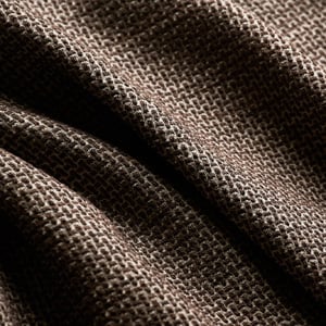 Close-up of a brown woven fabric with a fine textured weave, draped in soft folds
