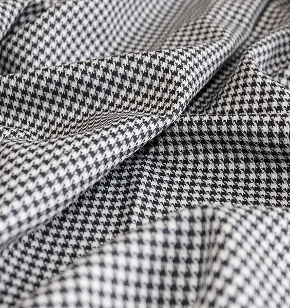 Close-up of black and white houndstooth fabric with soft folds and draping