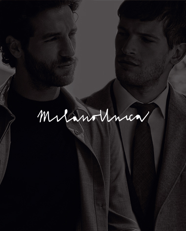 Two men in jackets, one wearing a tie, with the handwritten Milano Unica logo overlaid