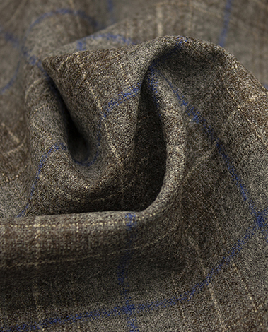 Close-up of brown wool fabric with a blue windowpane check, gathered in a soft swirl