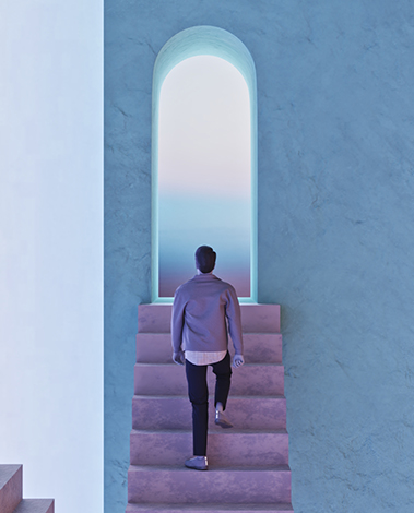 Man in a grey jacket climbs pale stairs toward a glowing arched opening in a blue textured wall
