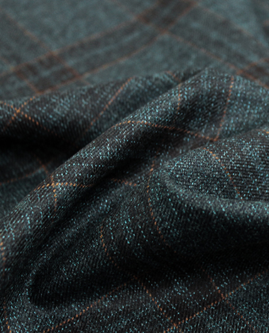 Close-up of draped dark green wool fabric with a thin orange check pattern