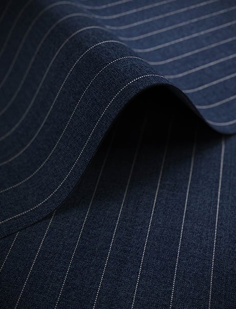 Navy blue wool fabric with thin white pinstripes, folded in a soft wave to show its texture