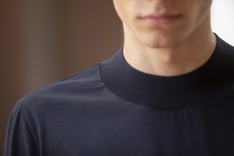 Close-up of a man's neck and shoulder in a dark navy top with a ribbed mock-neck collar