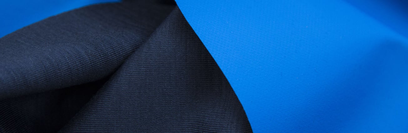 Close-up of folded navy knit fabric next to a smooth bright blue textile