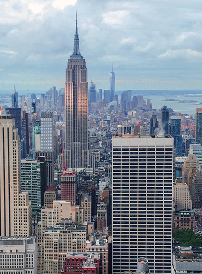 Empire State Building rising above the dense Manhattan skyline under a cloudy sky